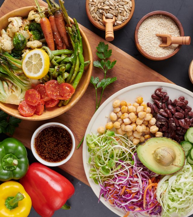 Vegan protein source. Buddha bowl dish, avocado, pepper, tomato, cucumber, red cabbage, chickpea, fresh lettuce salad and walnuts, nuts, beans, . Healthy vegetarian eating, super food. Top view.